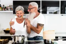 An older couple smiling in a kitchen