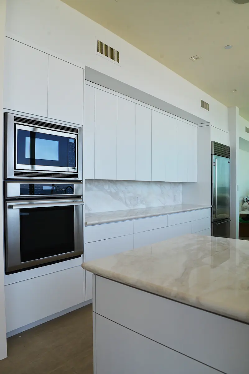 A kitchen with white stone countertops and islands