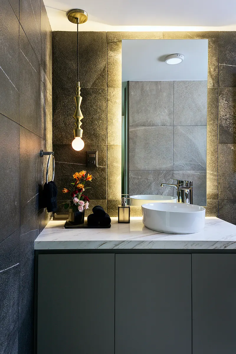 A bathroom sink decorated with dark gray stone