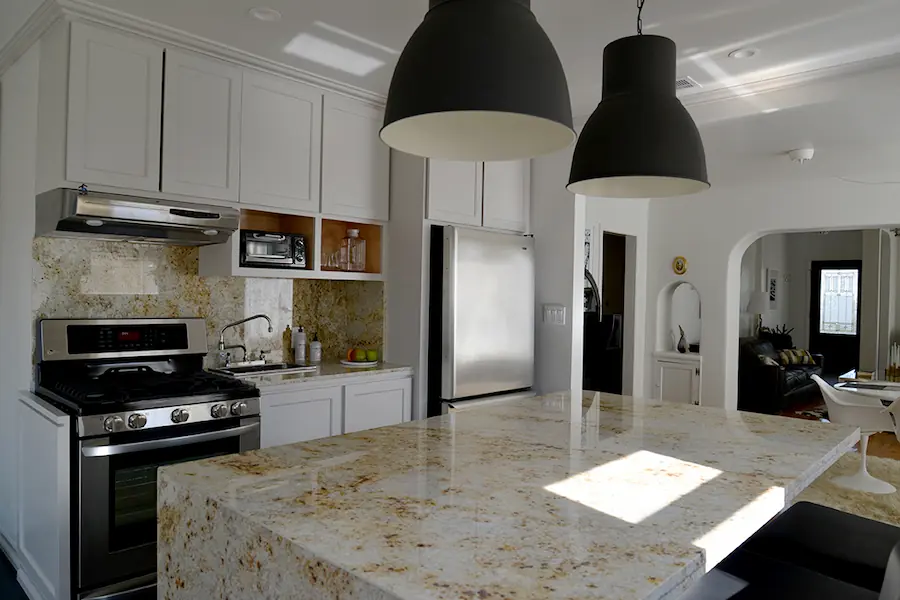 A kitchen finished with light, golden stone countertops