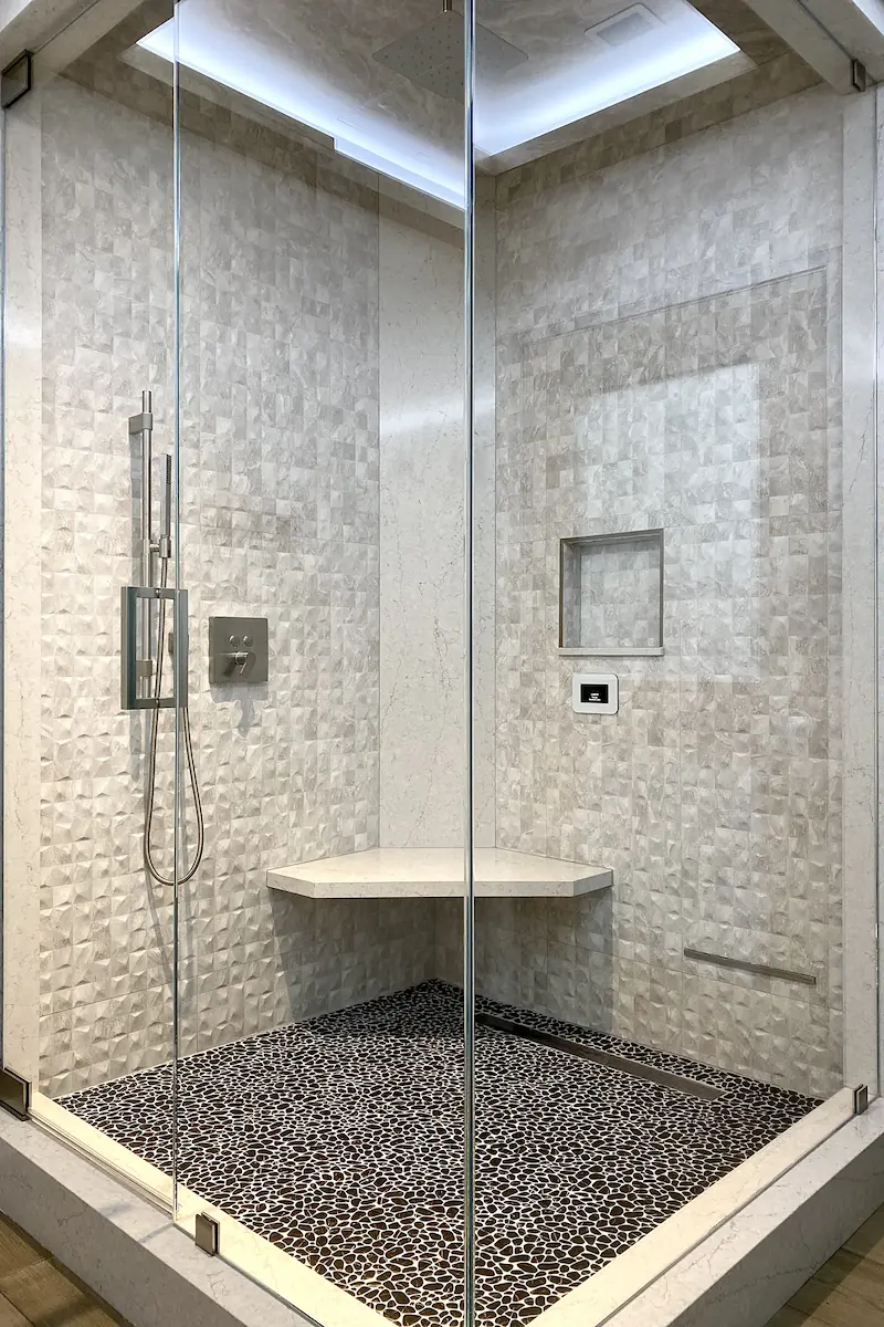 A bathroom shower decorated with light stone