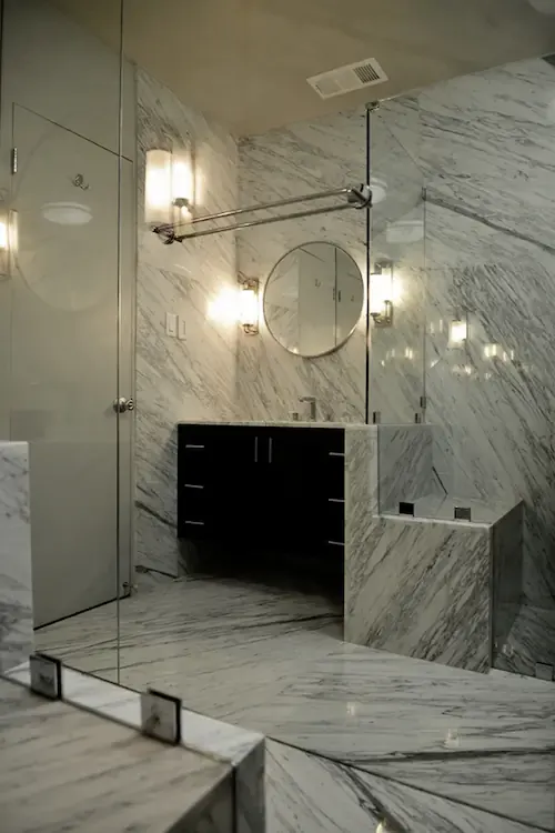 A bathroom shower decorated with light stone