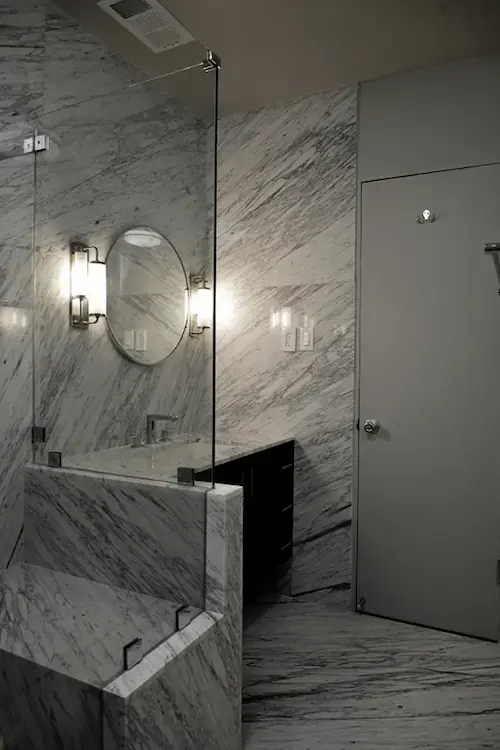 A bathroom shower decorated with light stone